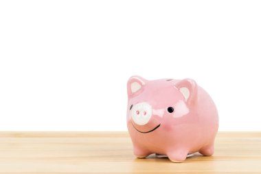 Domuz kumbarası ahşap masada, beyaz arka planda, tasarruf konsepti