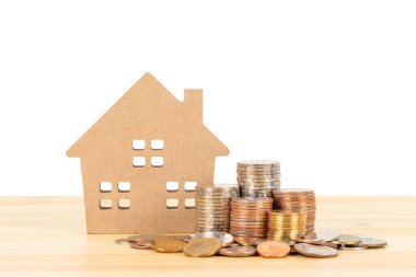 Para yığını ve model ev ahşap masa üzerinde beyaz arka plan, ipotek konsepti