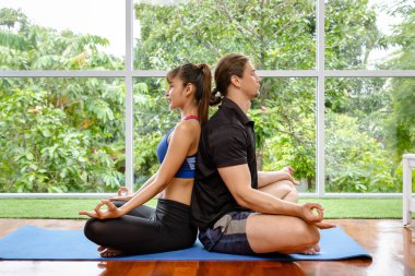 Karışık ırk çifti evde birlikte meditasyon yapıyorlar.