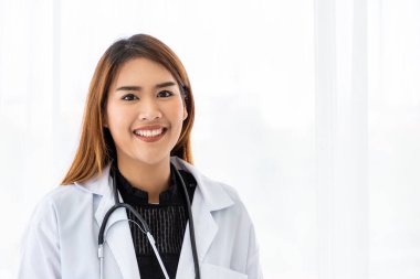 Kameraya bakan gülümseyen Asyalı bir tıp doktorunun portresi