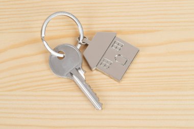 Evin anahtarı ahşap arka plan kavramı üzerinde ipotek için