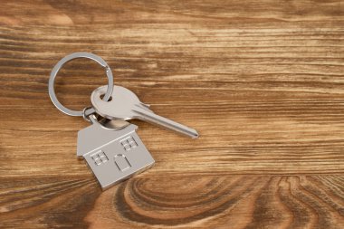 Evin anahtarı ahşap arka plan kavramı üzerinde ipotek için
