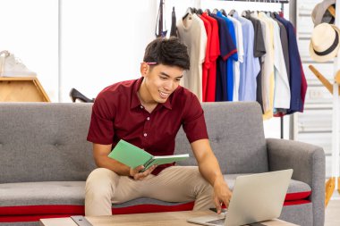 Genç Asyalı erkek online tüccar serbest blog yazarı evde dizüstü bilgisayarla çalışıyor. Sosyal medya, Nüfuz Edici ve online alışveriş konsepti.
