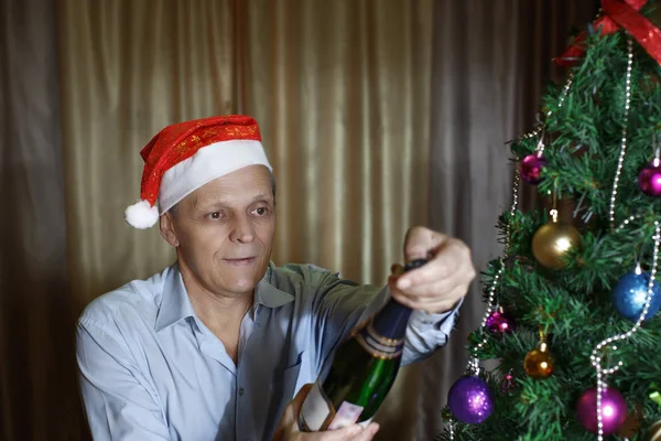 Hombre viejo, botella de champán, árbol de Navidad Imagen de archivo