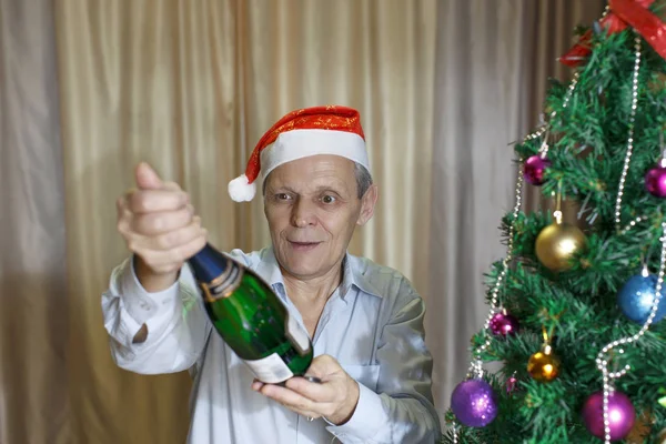 Bottiglia di champagne, abete di Natale, anziano Foto Stock