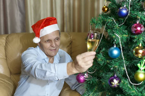 Älterer Herr, Glas Champagner, Tannenbaum lizenzfreie Stockfotos