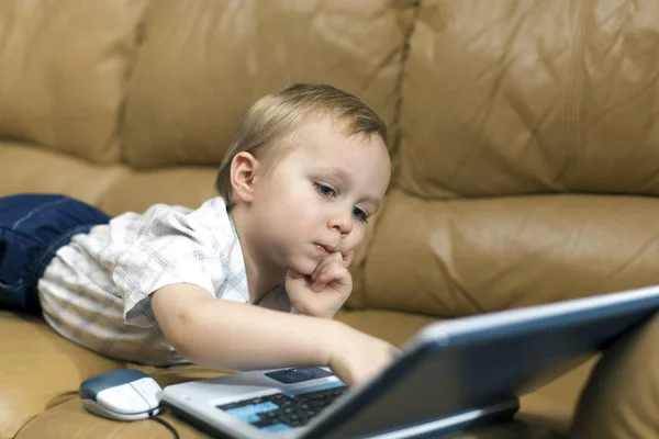 Menino está brincando no computador de ensino em casa no co — Fotografia de Stock