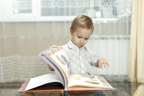 L'enfant voit son premier livre avec des photos en couleur — Photo