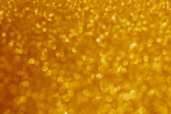 New Year,Xmas Golden abstract sparkles or glitter lights.2020.Defocused circles bokeh or particles.Template for design.Blurred golden holiday abstract glitter defocused background with blinking stars.