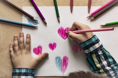 Kalem kalpli bebek eli çizimi. Sevgililer Günü, Anneler Günü ya da Babalar Günü için konsept. Bir çocuk kalem / kalemle kalp çizer. Üst Görünüm. 