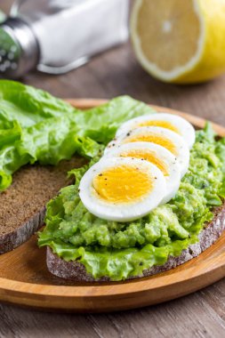 Sandviç ekmeği, püresi avokado, dilimlenmiş yumurta, yeşil salata, t