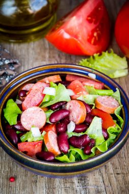 Fasulye, domates, soğan, tütsülenmiş sosis ve marul salatası