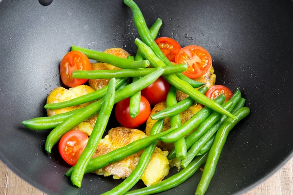 Roast vegetables in wok, potatoes, green beans, cherry tomatoes, — Stock Photo, Image