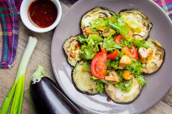 Ensalada con berenjena, champiñones, tomate, lechuga y salsa, sabrosa —  Fotos de Stock