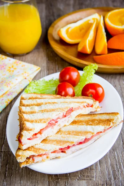 Sandwich a la parrilla, tostadas con queso, jamón y tomate, sabroso — Foto de Stock