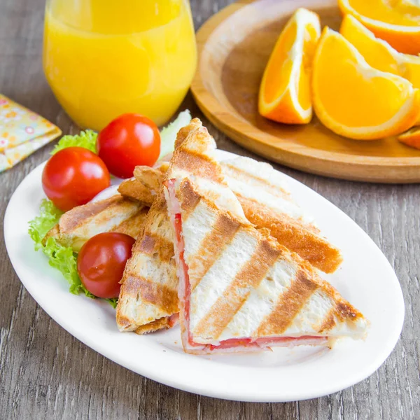 Жареный сэндвич, тост с сыром, ветчиной и помидорами, вкусно — стоковое фото