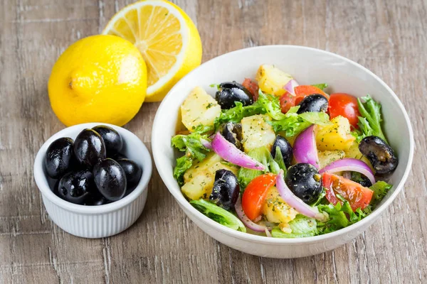 Aardappelsalade met olijven, tomaten, sla, rode ui, Italiaans — Stockfoto