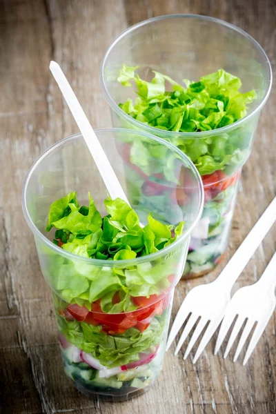 Ensalada de verduras frescas en vidrio desechable de plástico para picnic — Foto de Stock