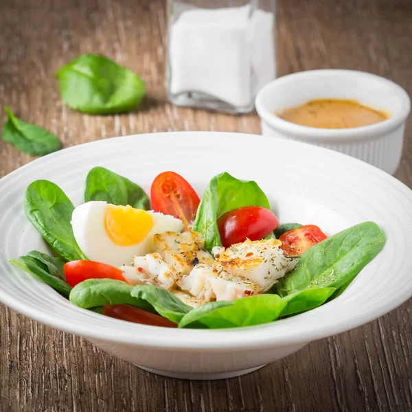 Insalata con spinaci, pesce bianco, merluzzo, fondo marino, dorado, ciliegia a — Foto Stock