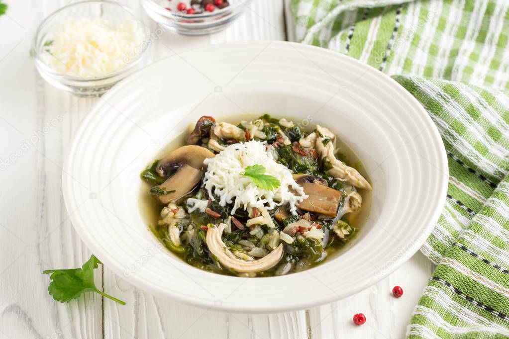 Healthy soup with spinach, chicken, rice, mushrooms and feta che