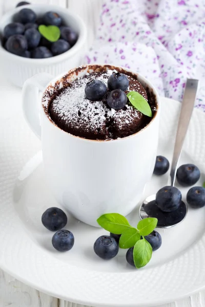 Chocolate cake in a mug with blueberry and powdered sugar — Stock Photo, Image