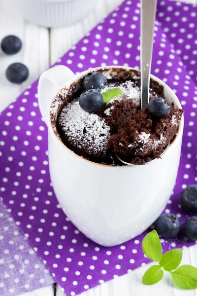 Chocolate cake in a mug with blueberry and powdered sugar — Stock Photo, Image