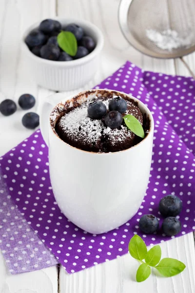 Chocolate cake in a mug with blueberry and powdered sugar — Stock Photo, Image