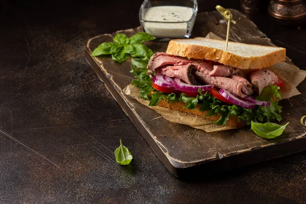 Смажений бутерброд з яловичиною з помідорами, цибулею, салатом та гірчичним тарілкою — стокове фото