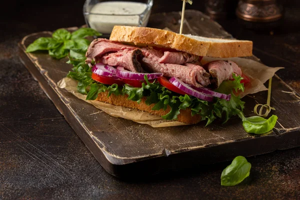 Смажений бутерброд з яловичиною з помідорами, цибулею, салатом та гірчичним тарілкою — стокове фото
