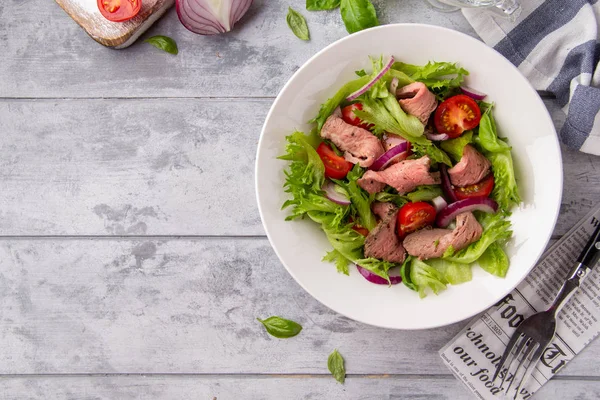 Salat mit Roastbeef, Tomaten, Zwiebeln, Salat und Senfsauce Stockfoto