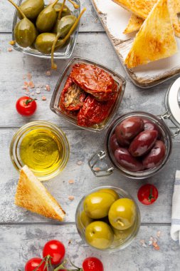 İtalyan antipasti, zeytin, kapari, güneşte kurutulmuş domates, zeytin yağı, ekmek (ciabatta, baget, kızarmış ekmek). Akdeniz yemekleri, lezzetli yemekler, şarap atıştırmalıkları.