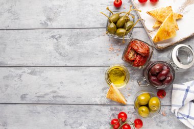 İtalyan antipasti, zeytin, kapari, güneşte kurutulmuş domates, zeytin yağı, ekmek (ciabatta, baget, kızarmış ekmek). Akdeniz yemekleri, lezzetli yemekler, şarap atıştırmalıkları.