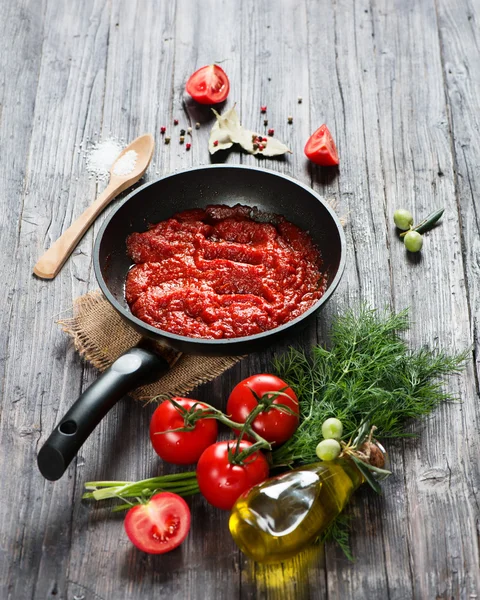 Molho de tomate em uma panela e ingredientes — Fotografia de Stock