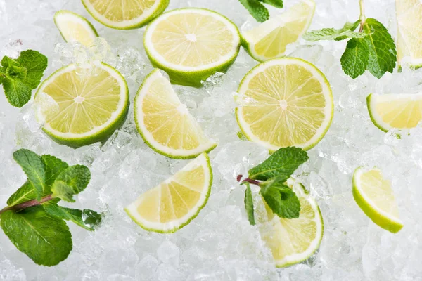 Saftig lime frukter på is kuber bakgrund. — Stockfoto