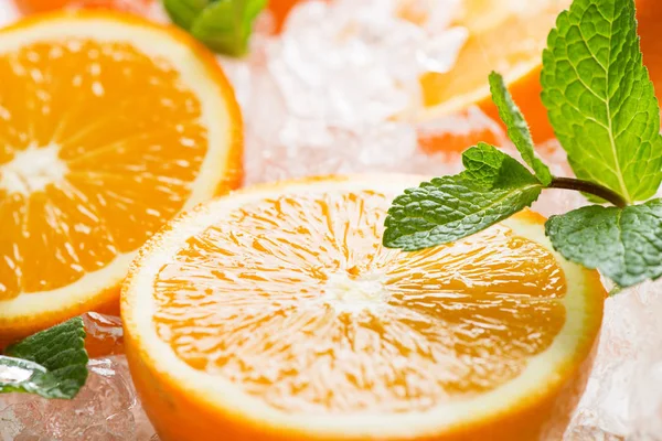 Halves of oranges and ice. — Stock Photo, Image