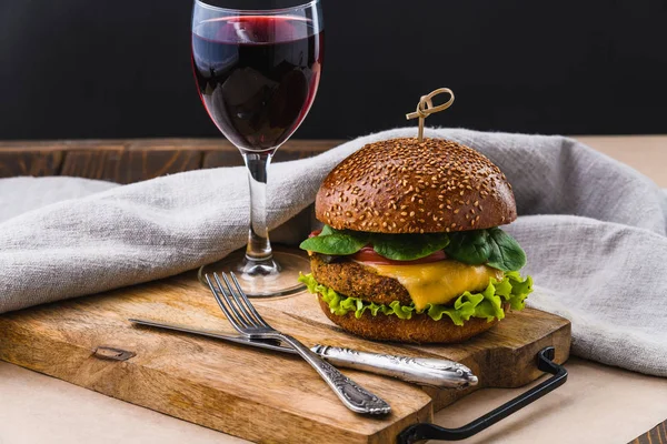 Vegetarian Burger with wine on wooden table