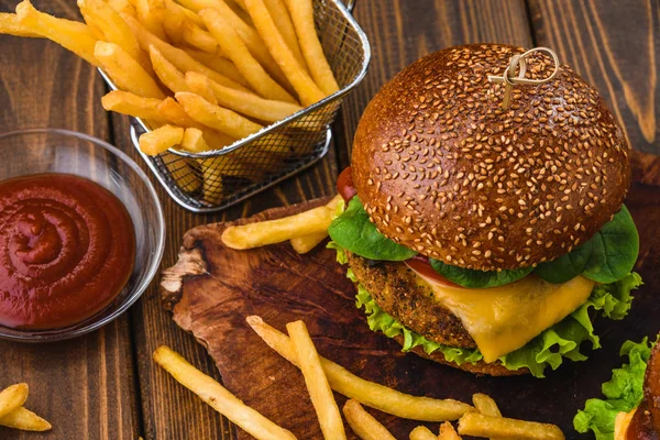 Vegetarian Burger with fries and drink on wooden table