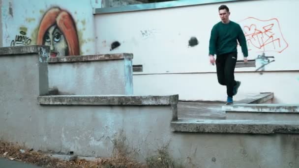 El tipo está entrenando a Parkour. Salta sobre la barandilla en un frío día de otoño. Hace una voltereta. Inteligentemente saltando. Parkour. . — Vídeos de Stock