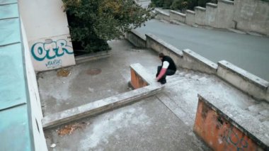 Adam parkour antrenmanı yapıyor. Soğuk bir sonbahar gününde korkuluklara atlıyor. Ters takla atıyor. Zekice atladın. Parkour.