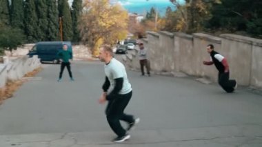 İki adam antrenman parkında. Bir sonbahar günü şehrin duvarlarına ve korkuluklarına atlamak. Akıllıca zıplayarak takla at. Parkour