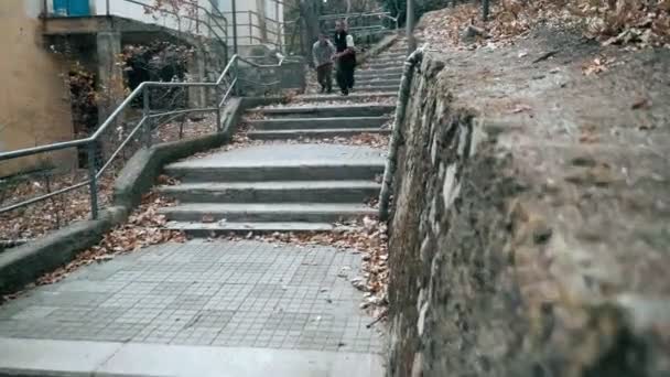 Два парня тренируют паркур. Они спрыгивают с лестницы, делая сальто назад в осенний день в городе . — стоковое видео