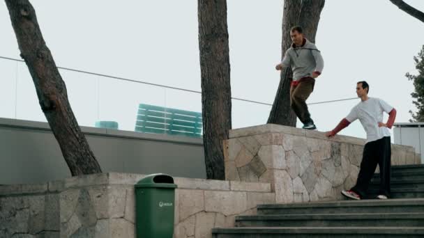 Hij traint parkour. Springt op de reling op een koude herfstdag. Doet een backflip. Slim springen. Parkour. — Stockvideo