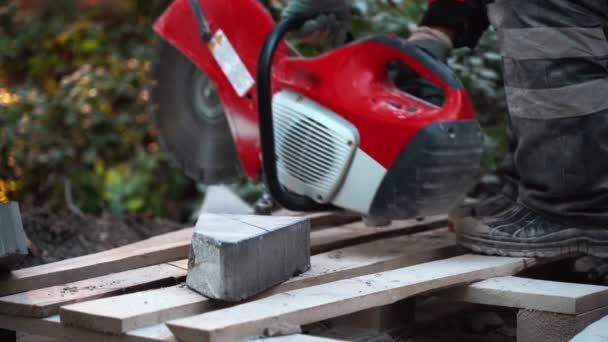 Рабочий включает инструмент после заправки бетонного резака и сглаживает тяжелую плиту для разреза. 4k — стоковое видео