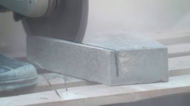 Beton kesme makinesi. Park alanında çalışan bir işçi parkta bir yürüyüş yolu için ağır plakalar kesiyor. Gün boyunca parkta beton kesiminde çalışıyor. Bir sürü toz serpintisi... 4K