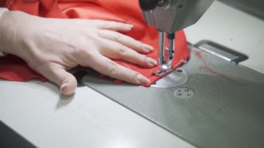 Kadın terzi, kırmızı elbise için hazırlık yapıyor.