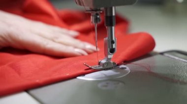 Kadın terzi, kırmızı elbise için hazırlık yapıyor.