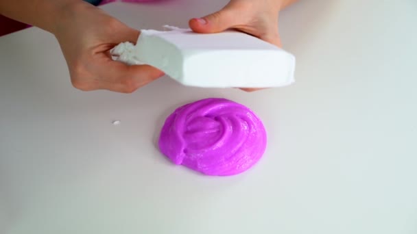 Les mains des filles jouent avec de la boue rose sur une table blanche. Utilise de l'argile blanche pour les slimes — Video