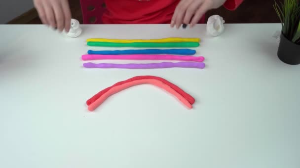 Mãos de uma menina fazendo um lodo de arco-íris em uma mesa branca . . — Vídeo de Stock