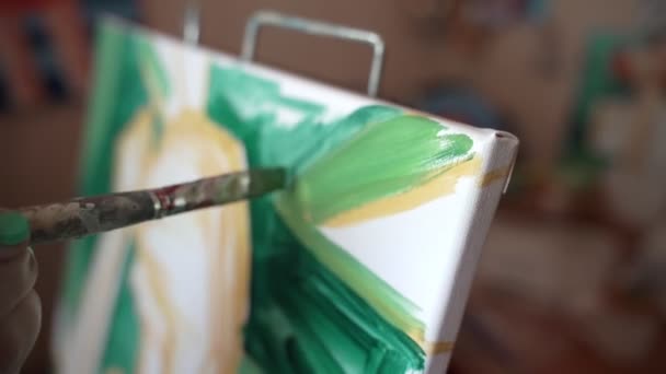 Dívka umělec v malé místnosti maluje obraz. — Stock video