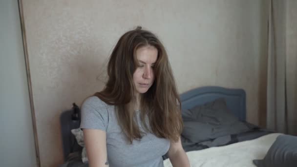 Ragazza artista si siede sul letto e comincia a raddrizzare i capelli — Video Stock